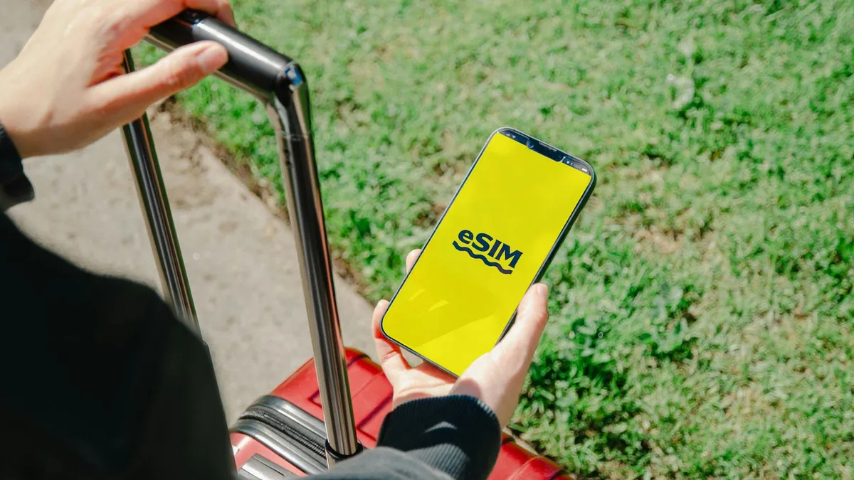 Smartphone con eSIM activa junto a tarjeta SIM física tradicional sobre mesa de café